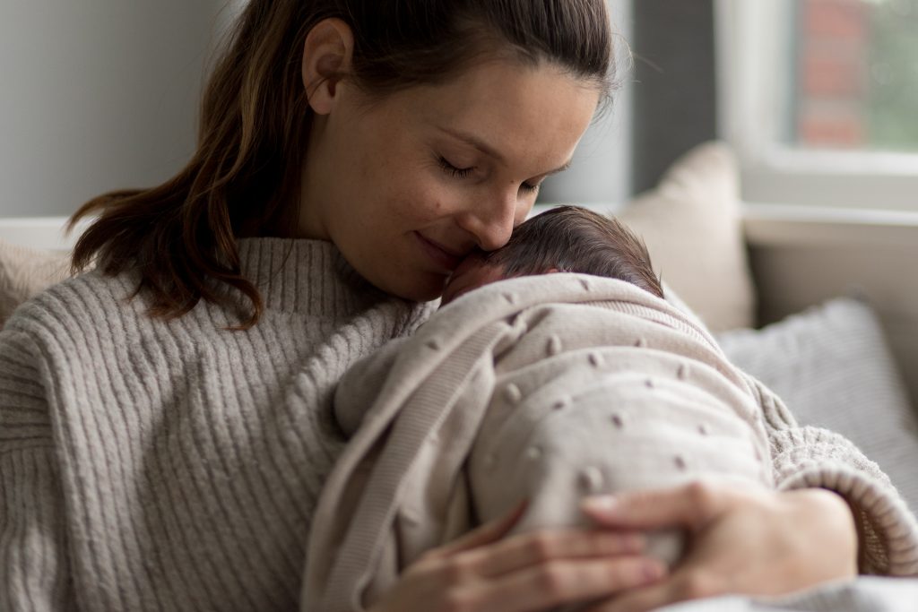 Kontakt Babyschlafcoaching Mama mit Kind im Arm kuschelnd Glücklich Schlafen Annika Braatz